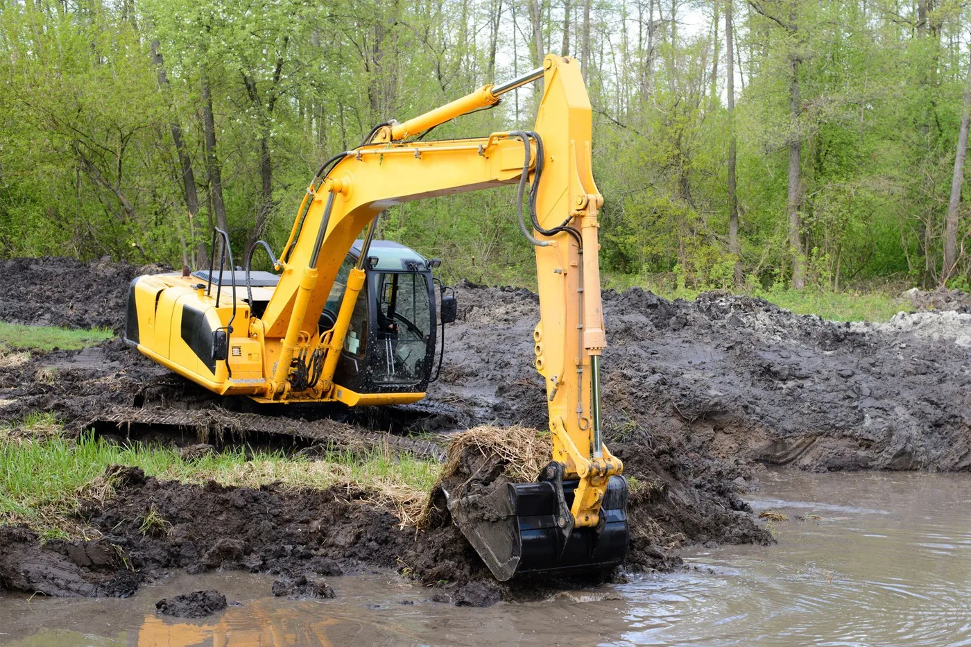 Excavator working wet ground on a pond dig